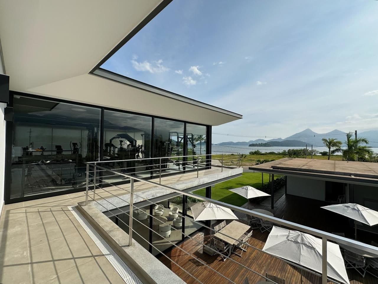 Varanda do clube com vista para a baía e as montanhas.