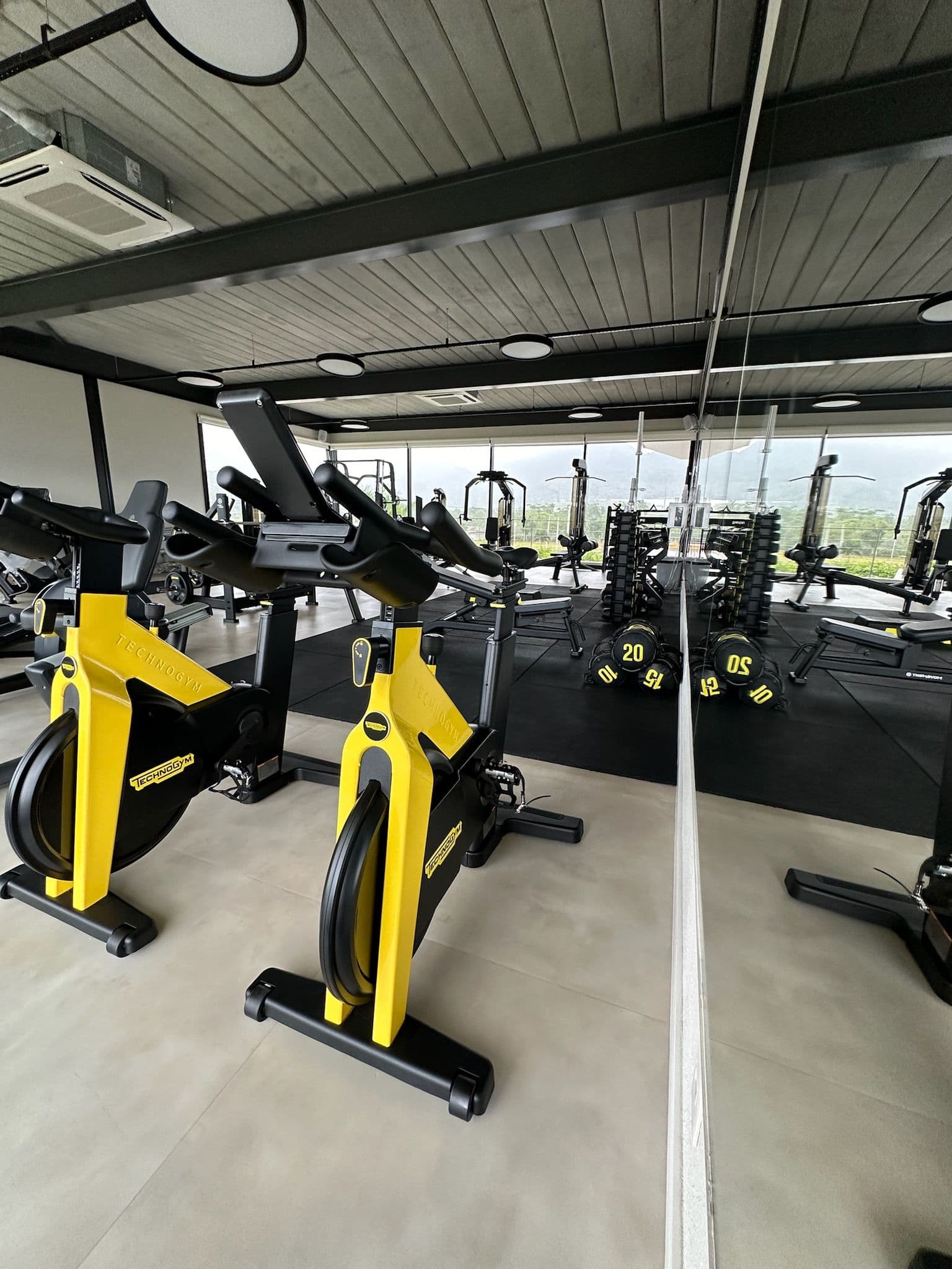 Academia do clube com bicicletas ergométricas amarelas.